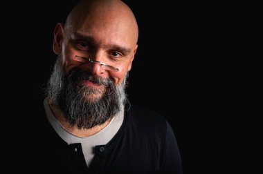 Uzun gri sakallı ve gözlüklü şık kel bir adamın duygusal yakın çekimi ciddi bir bakış yaratıyor. Eksantriklik, mizah ve anlamlı kişilik kavramı.