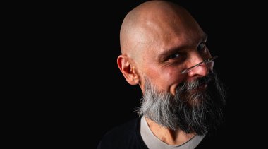 Uzun gri sakallı ve gözlüklü şık kel bir adamın duygusal yakın çekimi ciddi bir bakış yaratıyor. Eksantriklik, mizah ve anlamlı kişilik kavramı.