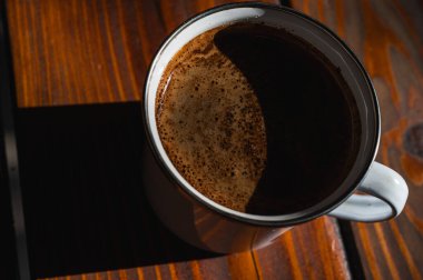 Seramik bardakta yeni demlenmiş sade kahvenin yakın çekimi. Zengin krema dokusu ve koyu kavrulmuş aroma. Mükemmel sabah içkisi ve rahat yaşam tarzı konsepti.