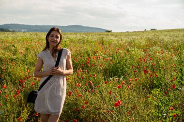 Küçük bir kız silikon tabancalı, renkli çizgili bir şey yapıyor.