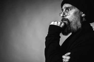 Düşüncelere dalmış gri sakallı, olgun bir adamın düşünceli portresi. Tek renkli, kopyalama alanı olan. Strateji ve sorun çözme kavramı