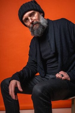 Sakallı, çözümü düşünen kendinden emin, entellektüel bir adam. Uzmanlık, yaratıcılık ve problem çözme kavramı. Turuncu üzerine izole edilmiş.