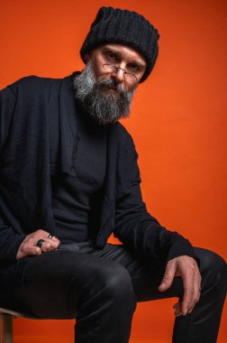 Sakallı, çözümü düşünen kendinden emin, entellektüel bir adam. Uzmanlık, yaratıcılık ve problem çözme kavramı. Turuncu üzerine izole edilmiş.