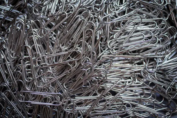 Kaotik ama organize olmuş gümüş ataç yığını birliği, bağlantıyı ve ofis gerekliliklerini vurguluyor. İş, eğitim ve yaratıcı kavramlar için mükemmel.