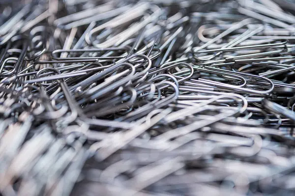 Kaotik ama organize olmuş gümüş ataç yığını birliği, bağlantıyı ve ofis gerekliliklerini vurguluyor. İş, eğitim ve yaratıcı kavramlar için mükemmel.