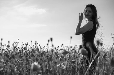 Parlak bir gökyüzünün altındaki haşhaş tarlasında kendine güvenen zarif bir kadın. Siyah ve beyaz, doğal güzelliğini ve düşünceli bakışlarını vurguluyor. Özgürlük, içgözlem ve kadınsı güç temaları için mükemmel.