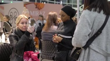 Helsinki, Finlandiya - 23 Ekim 2022: Bir güzellik mağazasında kozmetik ürünleri test eden ve alan ziyaretçiler. Fair I Love Me, Kuzey Avrupa 'nın en büyük sağlık, güzellik ve tarz aşıkları etkinliğidir.