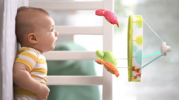 モバイルカルーセルと笑顔を見てベビーベッドで3ヶ月の赤ちゃん 幸せな子供だ 新生児はベビーベッドにいます 子供のためのモバイル 垂直ビデオ — ストック動画