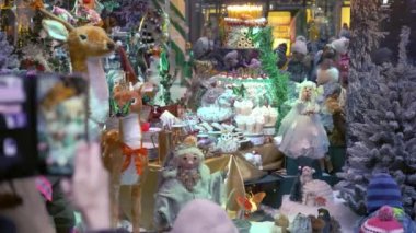 HELSINKI, FINLAND - 03 ARALIK 2022: Çocuklar ve yetişkinler Noel tatil vitrinlerini görüyorlar. Stockmann 'da geleneksel Noel gösterisi
