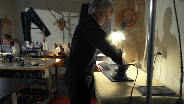 Μια Γυναίκα Ράφτρα Που Δουλεύει Ένα Συνεργείο Επισκευάζοντας Παλιά Παλιά — Αρχείο Βίντεο
