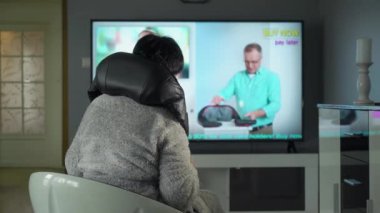 TV dükkanından alışveriş yapan orta yaşlı bir ev kadını. Profesyonel bir satıcı müşteriyi yeni, eşsiz bir elektrikli masaj aleti almaya ikna eder. Ağ reklamcılığı, TV mağazası, tele pazarlama, çevrimiçi satış.