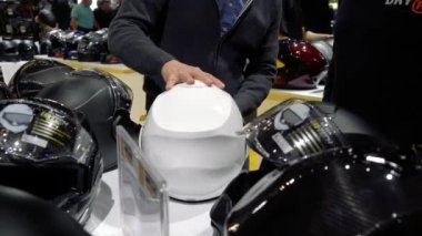 HELSINKI, FINLAND - Şubat 03, 2023: alıcılar motosiklet kasklarını seçerler. Motosikletler, motosikletler, scooterlar, binicilik ekipmanları, yedek parça ve birçok insan Kuzey ülkelerindeki en büyük motosiklet fuarında