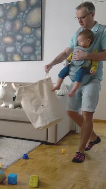 Padre Aspirapolvere Appartamento Pavimento Con Suo Bambino Nel Trasporto Fionda — Video Stock