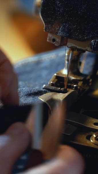 一位女裁缝在一家修理旧斜纹棉布衣服的车间里用老式真机缝制旧牛仔裤 小型家族企业 裁剪和修理服装 手工制作 — 图库视频影像