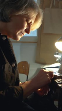 Bayan bir terzi, atölyede eski kot pantolon ve antika otantik bir makineyle eski kot elbiseleri tamir ediyor. Küçük aile şirketi, terzilik ve giysi onarımı, el yapımı, başlangıç.