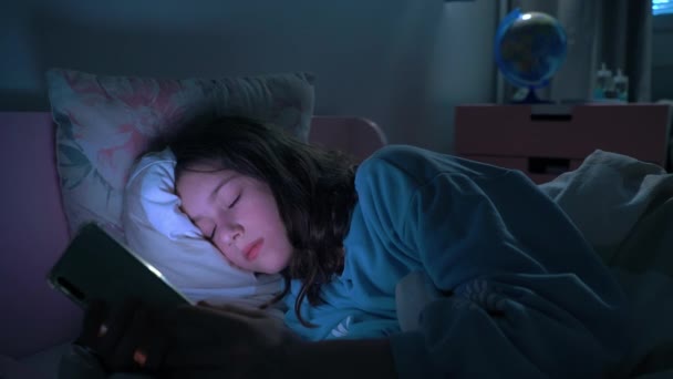 Genç Kız Gece Yatakta Yatarken Akıllı Telefon Kullanıyor Sosyal Medyayı — Stok video