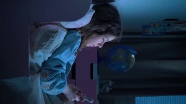 Genç kız gece yatakta yatarken akıllı telefon kullanıyor, sosyal medyayı karıştırıyor ve mesajlaşıyor. Sağlıklı uyku değil. Uykusuzluk ve yatmadan önce akıllı telefonun verdiği zarar. Sosyal ağlara bağımlılık