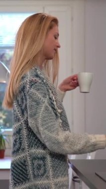 Dökme ve mutfakta kahve içme çekici genç kadın. Dolly vurdu.