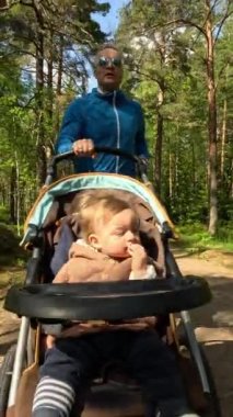 Finlandiya 'da bir parkta bebek arabasıyla koşan bir erkek koşucu..