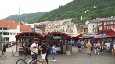 Bergen, Norway - Jun 23, 2023: The picturesque Bergen Fish Market located at the Citys harbor is one of Norways most visited outdoors markets. The Fish Market sells seafood, fruit and vegetables.