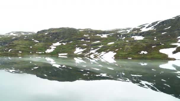 ノルウェーのアルパイン湖は一年中氷で覆われています マウンテンレイクの風景 寒い山の湖と山の雪 ドライビングプレート — ストック動画
