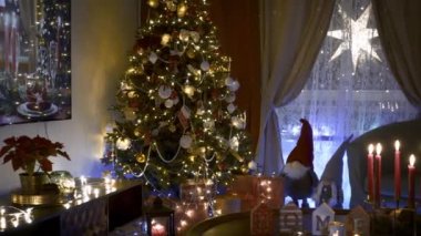 Geceleri oturma odasında Noel ağacı süslemeleri. Noel 'in içinde çelenkler, Noel ağacının altında hediyeler, Noel için her şey hazır..