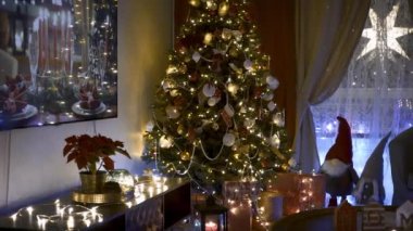 Geceleri oturma odasında Noel ağacı süslemeleri. Noel 'in içinde çelenkler, Noel ağacının altında hediyeler, Noel için her şey hazır..