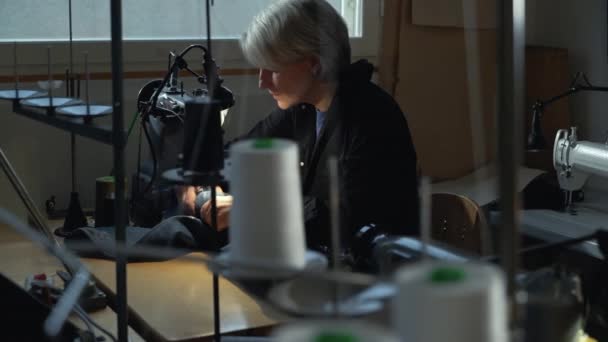 一位女裁缝在一家修整斜纹棉布衣服的车间里用老式织补机缝补旧牛仔裤 小型家族企业 裁剪和修理服装 手工制作 — 图库视频影像