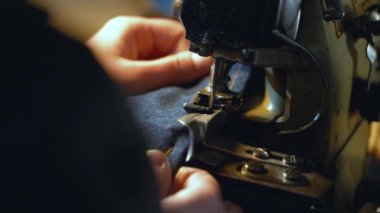 Bayan bir terzi, atölyede eski kot pantolon ve antika otantik bir makineyle eski kot elbiseleri tamir ediyor. Küçük aile şirketi, terzilik ve giysi onarımı, el yapımı, başlangıç