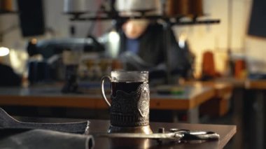 Sovyet tarzı bir atölyede, otantik dikiş makinelerinde eski kot pantolonları tamir eden klasik bardak tutacağı. Küçük aile şirketi, terzilik ve giysi onarımı, el yapımı, terzilik, gelenek