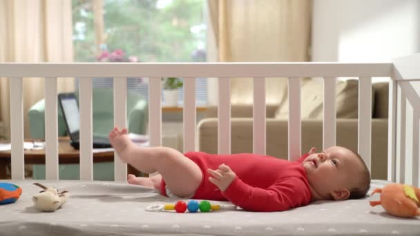 赤ん坊のベビーベッドで彼女の小さな赤ん坊にキスする若い美しいママ 母性について 美しい幸せな家族 — ストック動画