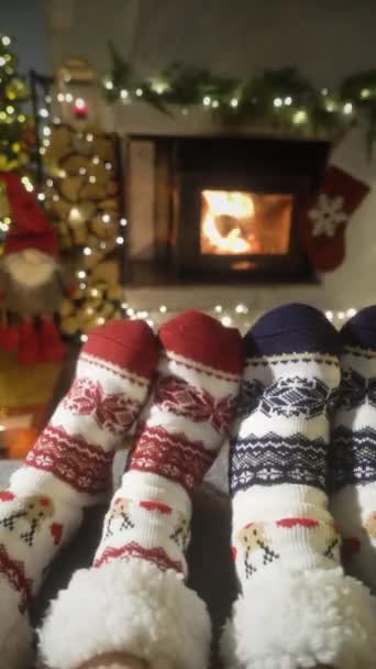 情侣们在温暖的壁炉边享受着 他们穿着毛袜 脚上挂着圣诞装饰品 圣诞树和装饰品 热得很 舒适的冬季 圣诞节和家庭 — 图库视频影像