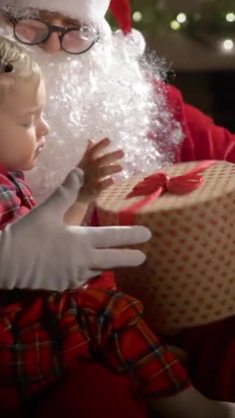 Ein Kleiner Junge Schlafanzug Und Der Weihnachtsmann Essen Weihnachtsplätzchen Mit — Stockvideo