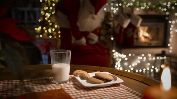Weihnachtsmann Legt Weihnachtsgeschenke Socken Über Den Kamin Isst Lebkuchen Und — Stockvideo