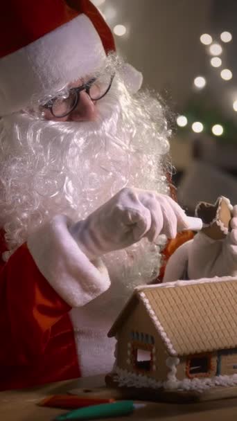Santa Claus Decorando Una Casa Jengibre Con Patrones Dulces Residencia — Vídeo de stock