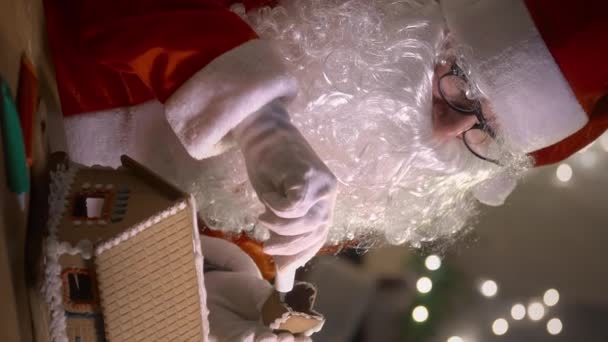 Der Weihnachtsmann Dekoriert Ein Lebkuchenhaus Mit Süßen Mustern Seiner Residenz — Stockvideo