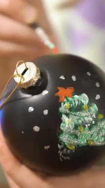 Noel arifesinde Noel süsleri çizen bir kız kutlamaya hazırlanıyor ve Noel ağacını süslüyor.