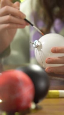 Noel arifesinde Noel süsleri çizen bir kız kutlamaya hazırlanıyor ve Noel ağacını süslüyor.