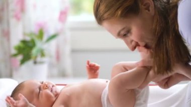 Annenin evde bebeğiyle oynaması, yeni doğanların ayaklarını öpmesi. Mutlu anne çocuk bakımı ve anneliğin tadını çıkarırken eğleniyor.