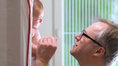 Baba, yeni doğmuş bebeğiyle kreşte oynuyor. Mutlu baba çocuğuyla bağ kurup babalık ve çocuk bakımı yapmaktan zevk alıyor. Çocuklar, bebek, ebeveynlik, çocukluk, hayat, aşk, babalık