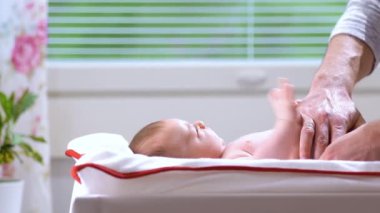 Orta yaşlı baba yeni doğan bebek için bebek bezi değiştiriyor. Erkek ebeveyn evde tek başına çocuğuna bakıyor. Gerçek hayatta samimi anlar. Bekar baba aile hayatı. Mutlu baba babalığı ve çocuk bakımını seviyor.