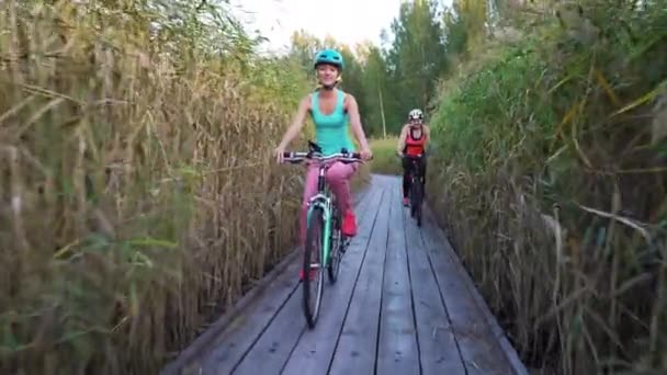 Dvě Mladé Ženy Jezdí Kole Dřevěné Ekologické Stopě Rákosí — Stock video