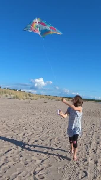快乐的小女孩在美丽的北方海滩上与一只五彩缤纷的风筝玩耍 积极的夏季家庭海上度假 在海滨玩耍的孩子 — 图库视频影像