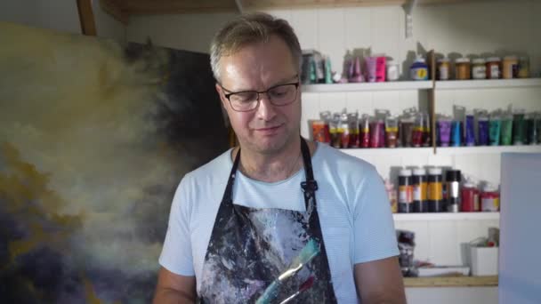 Eine Männliche Künstlerin Posiert Vor Dem Hintergrund Ihrer Malerei Atelier — Stockvideo