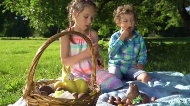 Zwei Kinder Haben Spaß Und Essen Schokoladeneier Nach Ostereiersuche Garten — Stockvideo
