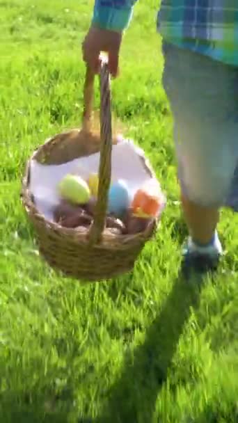 一个小男孩带着篮子在花园后院猎取复活节彩蛋 — 图库视频影像