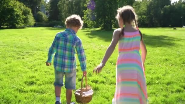两个男孩和女孩在花园后院打猎复活节彩蛋 — 图库视频影像