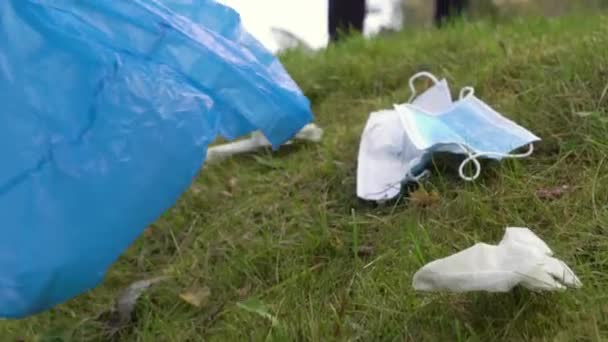 志愿人员在巴士站附近和公路沿线收集一次性医疗面罩和手套 大流行病期间的环境污染问题 — 图库视频影像