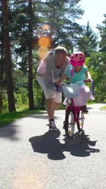 İlk Bisiklete binme. Baba kızı Bisiklete binmeyi öğretir.