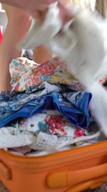 Genç bir kadın gelişigüzel ambalaj ve takoz-bavul kapatmaya çalışırken. Yakın çekim